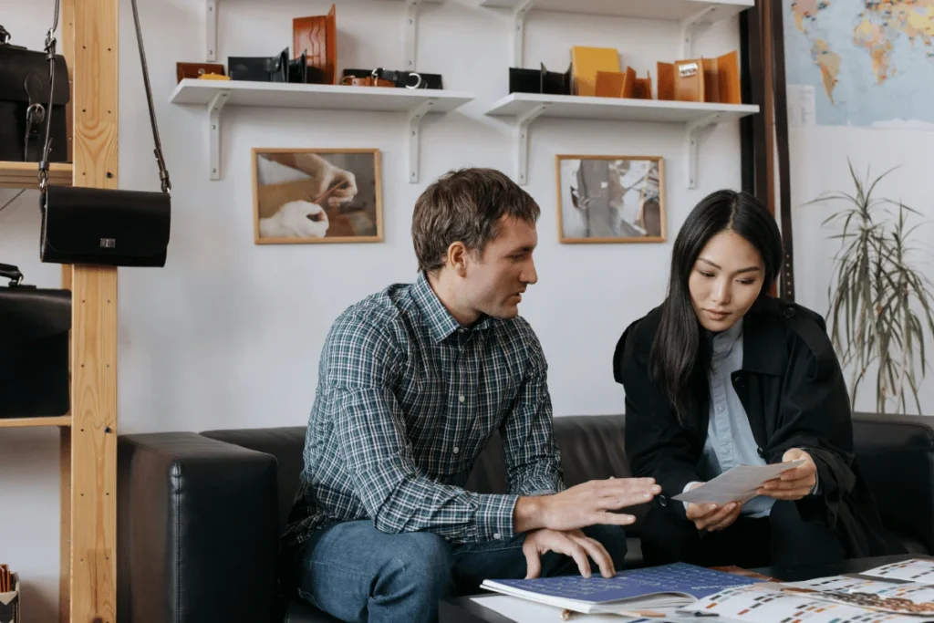 Man and woman collaborating on documents in a modern office.